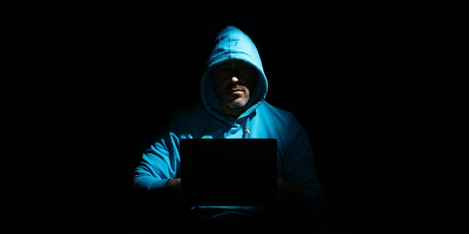 hacker con cappuccio nell'ombra truffa online